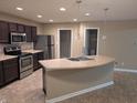 Modern kitchen with stainless steel appliances, dark wood cabinets, and a functional center island at 8354 Fieldfare Way, Indianapolis, IN 46237
