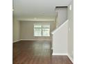 An open living room featuring wood-look floors and bright natural light from a large window at 8354 Fieldfare Way, Indianapolis, IN 46237