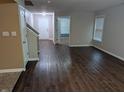 Inviting living room featuring sleek, dark wood floors, neutral walls, and a bright, open entryway at 8354 Fieldfare Way, Indianapolis, IN 46237