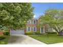 Beautiful brick home featuring a manicured lawn, mature trees, and a two-car garage for curb appeal at 8430 Harrison Pkwy, Fishers, IN 46038