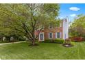 Attractive two-story brick home with lush green lawn, mature tree, and tidy landscaping for a welcoming aesthetic at 8430 Harrison Pkwy, Fishers, IN 46038