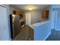 Functional kitchen features wood cabinets, stainless-steel refrigerator, and a breakfast bar at 9145 Blue Pine Dr, Indianapolis, IN 46231
