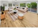 Bright living room features hardwood floors, white sofa, area rug, and sliding glass doors to a deck at 9490 E 36Th Pl, Indianapolis, IN 46235