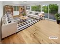 Bright living room featuring hardwood floors, large windows, and stylish furniture. (Virtually Staged) at 9490 E 36Th Pl, Indianapolis, IN 46235