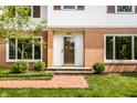 Attractive front entrance with brick accents, large windows, and a glass front door, complemented by lush landscaping at 100 Wellington Rd, Indianapolis, IN 46260