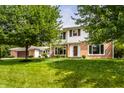Inviting two-story brick home with white siding, large trees, and a lush green lawn creating curb appeal at 100 Wellington Rd, Indianapolis, IN 46260