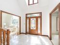 Bright foyer featuring tile floors, a decorative glass door, and staircase at 10350 Courageous Dr, Indianapolis, IN 46236