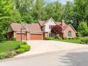 Brick home with well-manicured lawn and three-car garage on a lush lot at 10350 Courageous Dr, Indianapolis, IN 46236