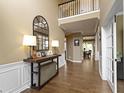 Grand foyer with hardwood floors, two-story ceilings, and decorative console table with mirror at 11872 Traymoore Dr, Fishers, IN 46038