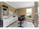 Well-lit home office features built-in shelving, neutral paint and large window at 11872 Traymoore Dr, Fishers, IN 46038
