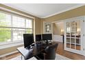 Bright home office with french doors, large window and a dark desk set at 11872 Traymoore Dr, Fishers, IN 46038