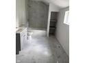 Updated bathroom featuring modern fixtures, a tiled shower/tub, and stylish marble tile flooring at 1322 S Belmont Ave, Indianapolis, IN 46221
