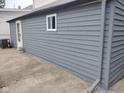 View of gray detached garage with white trim and concrete driveway at 1322 S Belmont Ave, Indianapolis, IN 46221