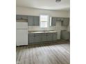 Bright kitchen features gray cabinets, granite countertops, stainless steel sink and modern appliances at 1322 S Belmont Ave, Indianapolis, IN 46221