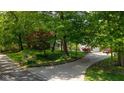 Long, curved driveway leading to a charming ranch-style home surrounded by trees at 13300 Fairwood Dr, McCordsville, IN 46055