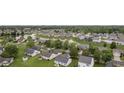 Wide aerial view of a neighborhood, featuring a pond and tree-lined streets with well-maintained lawns and landscaping at 1431 Evergreen Dr, Greenfield, IN 46140