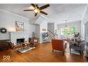 Spacious living room with hardwood floors, a decorative fireplace, and staircase at 1497 Clinton St, Noblesville, IN 46060