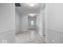 Bright hallway with tiled flooring, elegant wall trim, and a view of the front door with glass panels at 16573 Cava Dr, Fishers, IN 46037