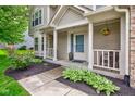 Inviting front porch with decorative hanging plants and manicured landscaping at 18915 Fairfield Blvd, Noblesville, IN 46060