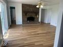 Bright living room featuring hardwood floors, a brick fireplace, and a sliding glass door at 1925 W State Road 32, Lebanon, IN 46052