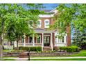 Lovely two-story home with a welcoming front porch, brick facade, lush landscaping, and a well-maintained lawn at 2037 Stanhope St, Carmel, IN 46032