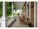 Relaxing front porch with rocking chairs, offering a cozy outdoor space with brick walls and white columns at 2037 Stanhope St, Carmel, IN 46032