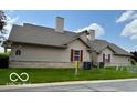 Angle view of the home's exterior with well-kept lawn and neutral-colored siding at 3016 Wildcat Ln, Indianapolis, IN 46203