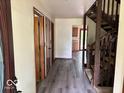 Hallway featuring hardwood floors, staircase to the right, and doors leading to other rooms at 310 S Shady Ln, Muncie, IN 47304