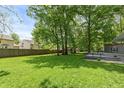 Spacious backyard with mature trees and a wooden fence at 3333 Melbourne S Rd, Indianapolis, IN 46228