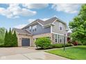 A large home with a three-car garage, brick and siding exterior and a well-manicured lawn at 3744 Abney Point Dr, Carmel, IN 46077