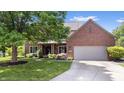 Inviting brick home with attached garage, lush lawn, and mature tree offering curb appeal at 3823 Brigade Cir, Carmel, IN 46032