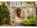 Inviting front entrance with a decorative canopy, red door, brick facade, and lush ferns at 3840 N Washington Blvd, Indianapolis, IN 46205