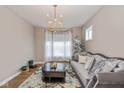 Comfortable living room with a stylish couch, elegant chandelier, and large windows at 4061 Secretariat Ln, Bargersville, IN 46106