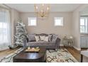 Cozy living room with stylish sofa, decorative tree, and elegant chandelier at 4061 Secretariat Ln, Bargersville, IN 46106