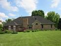 Spacious backyard with a brick home, chimney, lush lawn and large wood deck at 4288 Silver Hill Dr, Greenwood, IN 46142