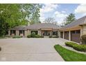 Beautiful stone home showcasing a large driveway, three-car garage, and professional landscaping at 470 Mill Farm Rd, Noblesville, IN 46062