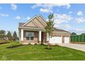 Charming brick home featuring a three-car garage and well-manicured lawn under a partly cloudy sky at 5032 Carmine St, Brownsburg, IN 46112