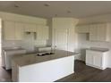 Bright kitchen features white cabinets, an island with quartz countertop, and stainless steel double sink at 5203 Cartland Dr, Indianapolis, IN 46239