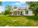 Charming two-story farmhouse with a covered porch and surrounded by green lawn at 5335 W 550 S, Trafalgar, IN 46181