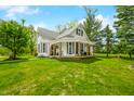 Inviting two-story farmhouse with a cozy covered porch and green lawn at 5335 W 550 S, Trafalgar, IN 46181