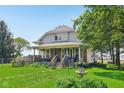 Charming two-story home featuring a covered front porch, steps to the front door, and mature trees on a lush green lawn at 5758 N 1200 E, Sheridan, IN 46069