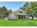 Charming two-story home featuring a covered front porch, steps to the front door, and mature trees on a lush green lawn at 5758 N 1200 E, Sheridan, IN 46069