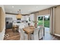 Bright kitchen featuring white cabinets, stainless steel appliances, an island, and an adjacent dining area at 5931 Sterling Dr, Whitestown, IN 46075