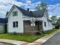 Quaint home featuring a covered front porch, well-maintained lawn, and classic architectural details at 600 S Oak St, Fortville, IN 46040