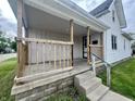 Inviting front porch with wooden railing, steps leading to the entrance, and a view of the home's facade at 600 S Oak St, Fortville, IN 46040