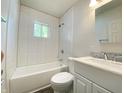 Bright bathroom with a white vanity, toilet, and tub with white subway tile at 6150 E 25Th St, Indianapolis, IN 46219