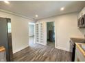 Open kitchen featuring stainless appliances, white cabinets, built-in shelving and wood look flooring at 6150 E 25Th St, Indianapolis, IN 46219