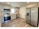 Modern kitchen features stainless steel appliances, grey cabinets, wood countertops, and wood flooring at 6150 E 25Th St, Indianapolis, IN 46219