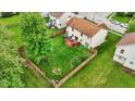 Aerial view of a spacious, fenced backyard with a deck, play area, fire pit, and hammock at 6609 Fountain Springs Blvd, Indianapolis, IN 46236