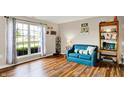 Cozy living room with hardwood floors, large window, and comfortable blue couch at 6609 Fountain Springs Blvd, Indianapolis, IN 46236